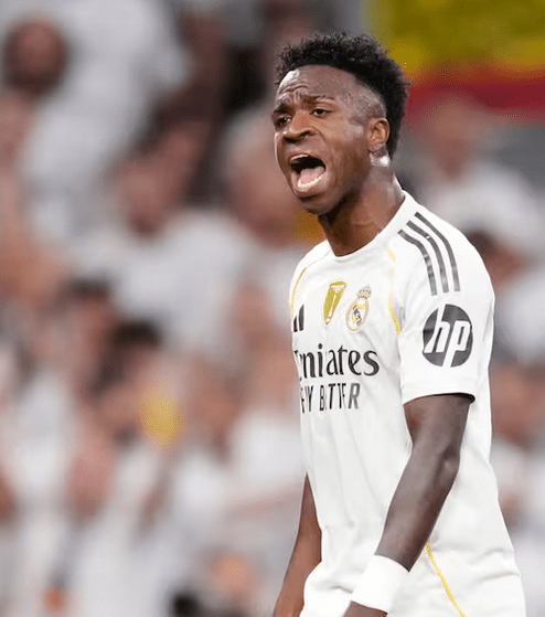Jugador del Real Madrid gritando durante un partido, vistiendo su uniforme blanco con detalles en negro.