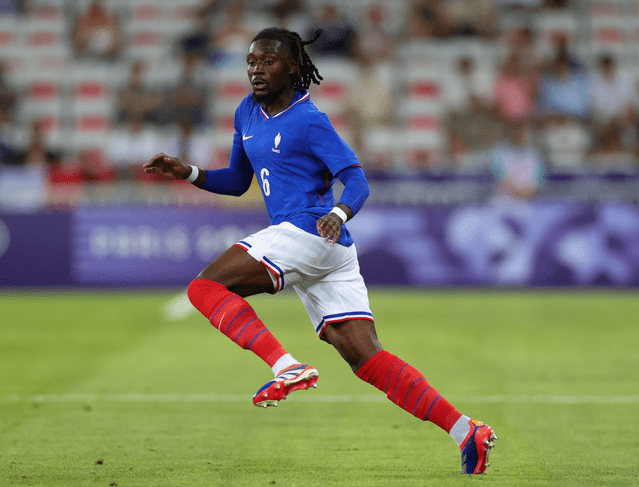 Jugador de fútbol corriendo en un partido, vistiendo la camiseta de Francia con el número 6 y shorts blancos.